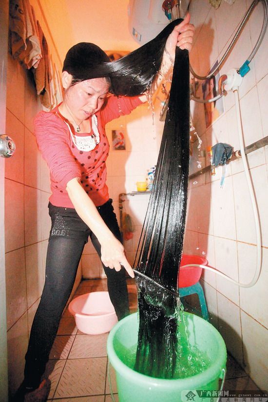 “长发婆”岑英源在洗发。记者 何学俏 摄